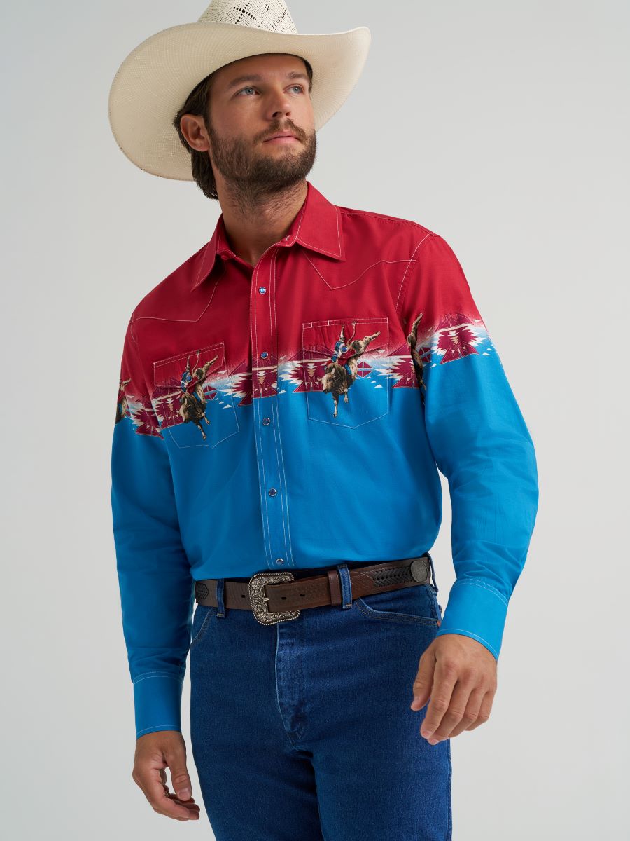 Man wearing a red and blue patterned Wrangler shirt with a cowboy hat on a gray background