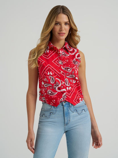 Woman wearing a red Wrangler paisley tank top and blue jeans on a grey background