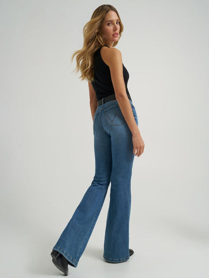 Woman wearing blue flared jeans and a black top on a white background