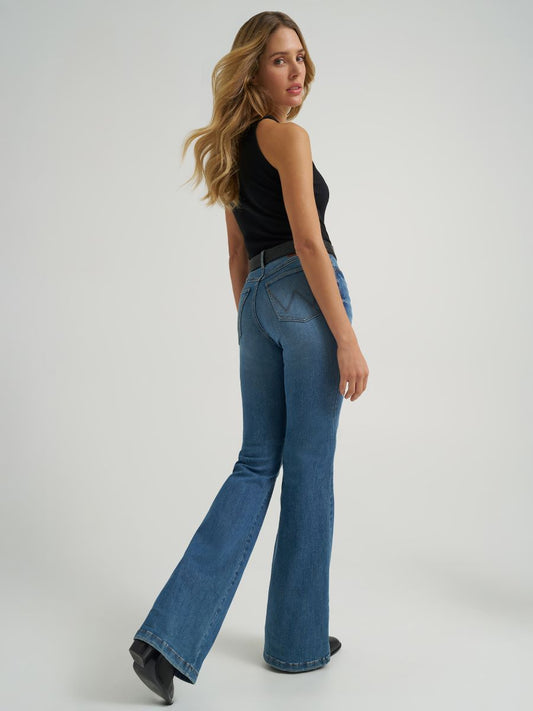 Woman wearing blue flared jeans and a black top on a white background