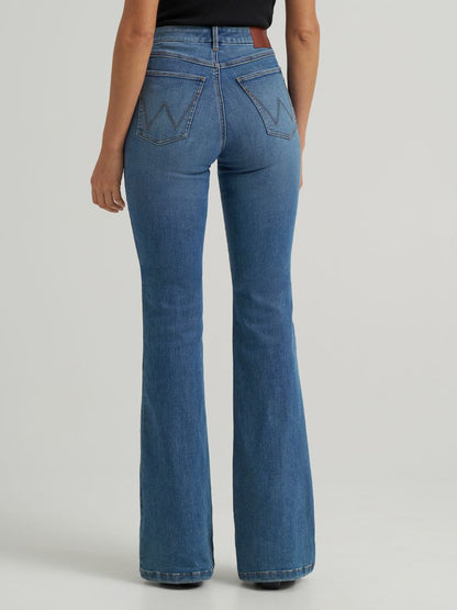 Blue flared jeans worn by a woman on a light gray background