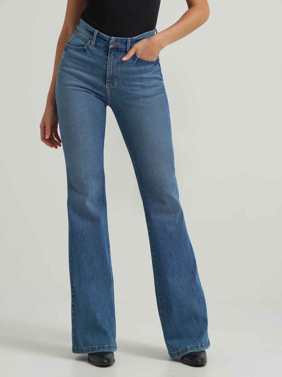 Person wearing blue flared jeans on a plain background