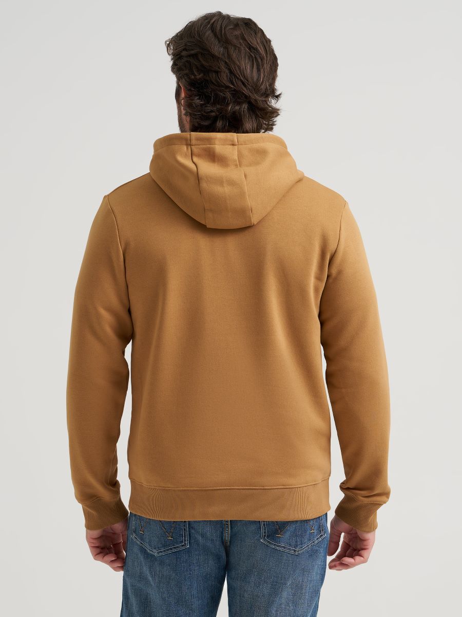 A man viewed from the back wearing a solid tobacco brown Wrangler pullover hoodie and blue jeans, set against a plain light gray studio background.
