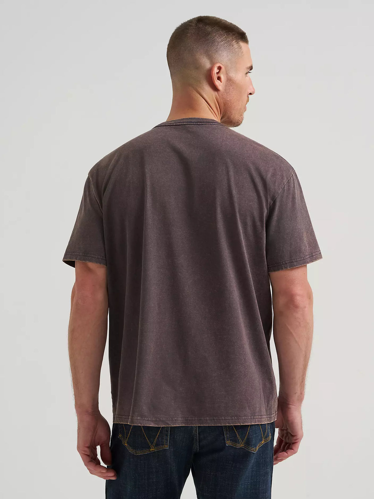 man wearing a Wrangler t shirt and jeans on a white background