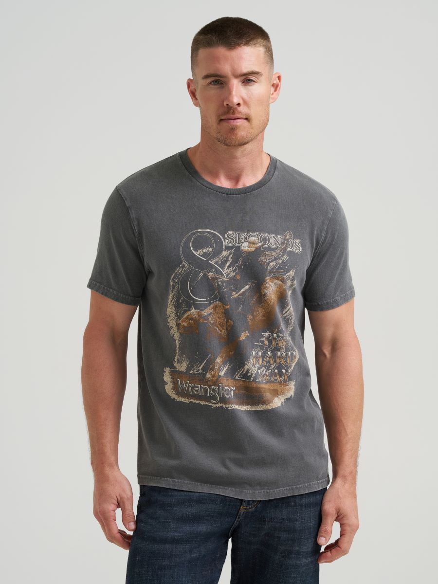 Man wearing a black Wrangler t-shirt with a graphic design on a plain background