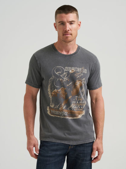 Man wearing a black Wrangler t-shirt with a graphic design on a plain background