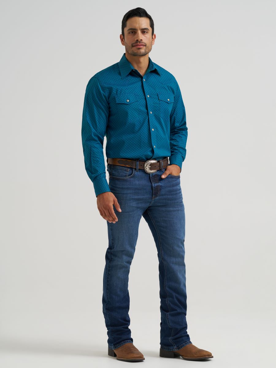 Man wearing a blue Wrangler shirt and jeans on a white background