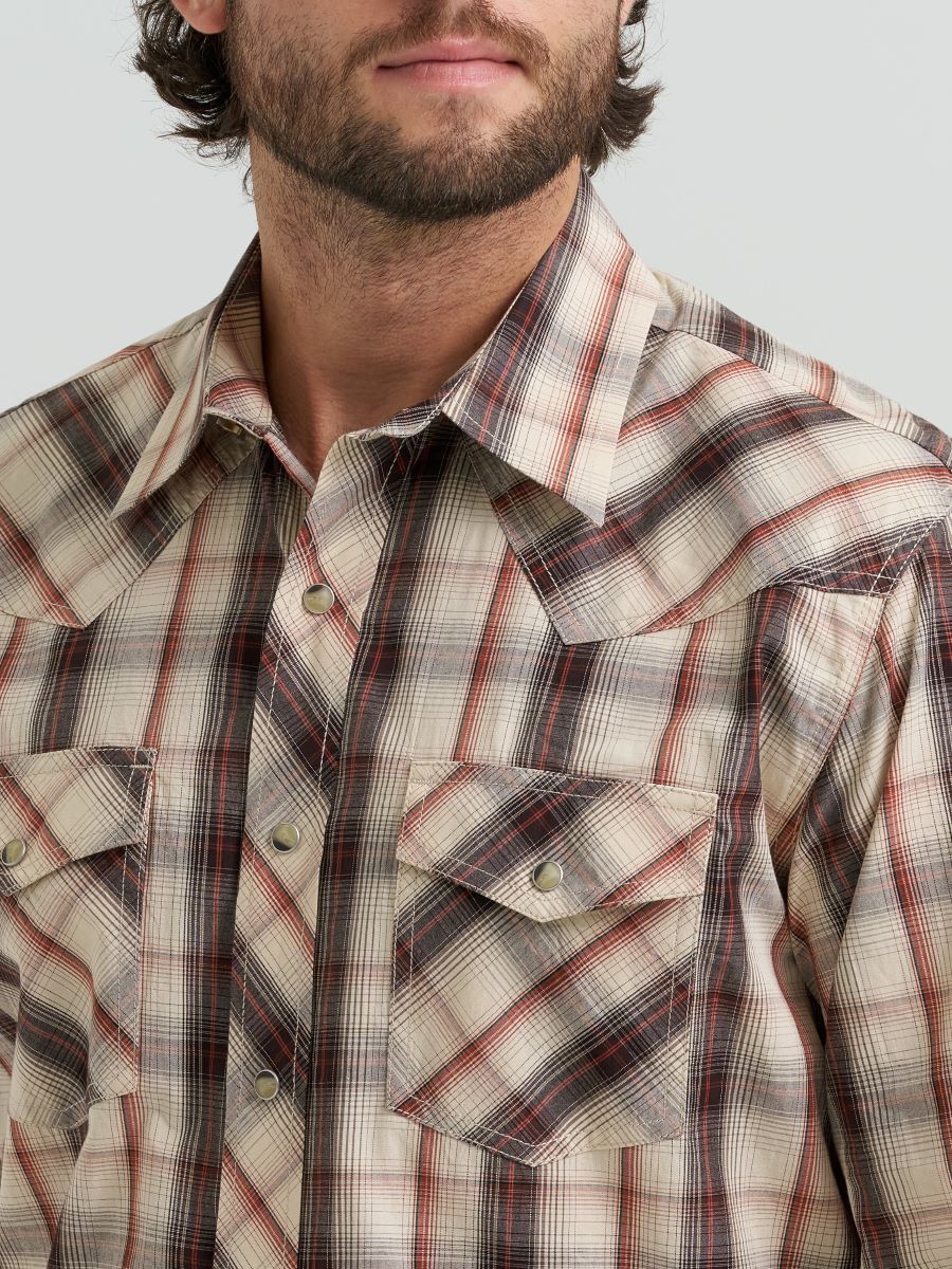 Man wearing a plaid Wrangler shirt with a neutral background
