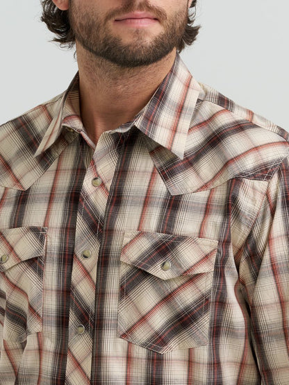 Man wearing a plaid Wrangler shirt with a neutral background