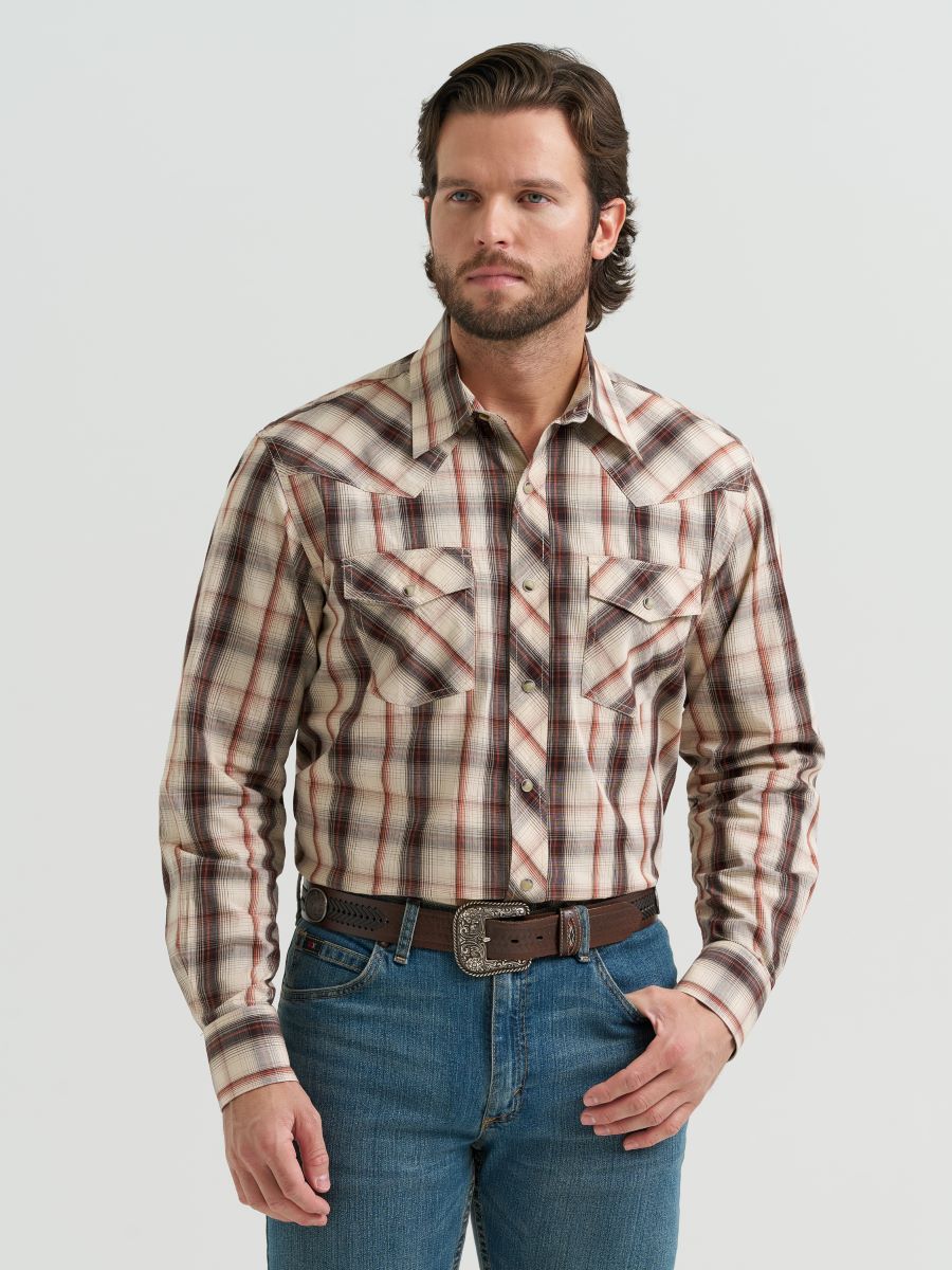 Man wearing a brown plaid Wrangler shirt and jeans on a light gray background