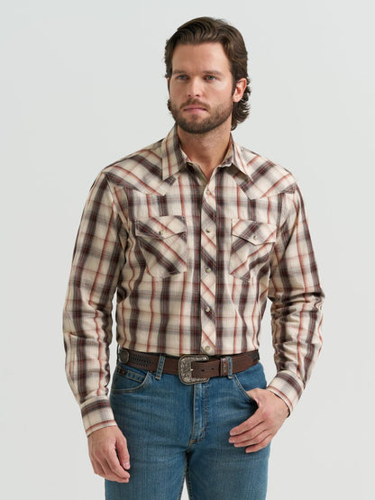 Man wearing a brown plaid Wrangler shirt and jeans on a light gray background