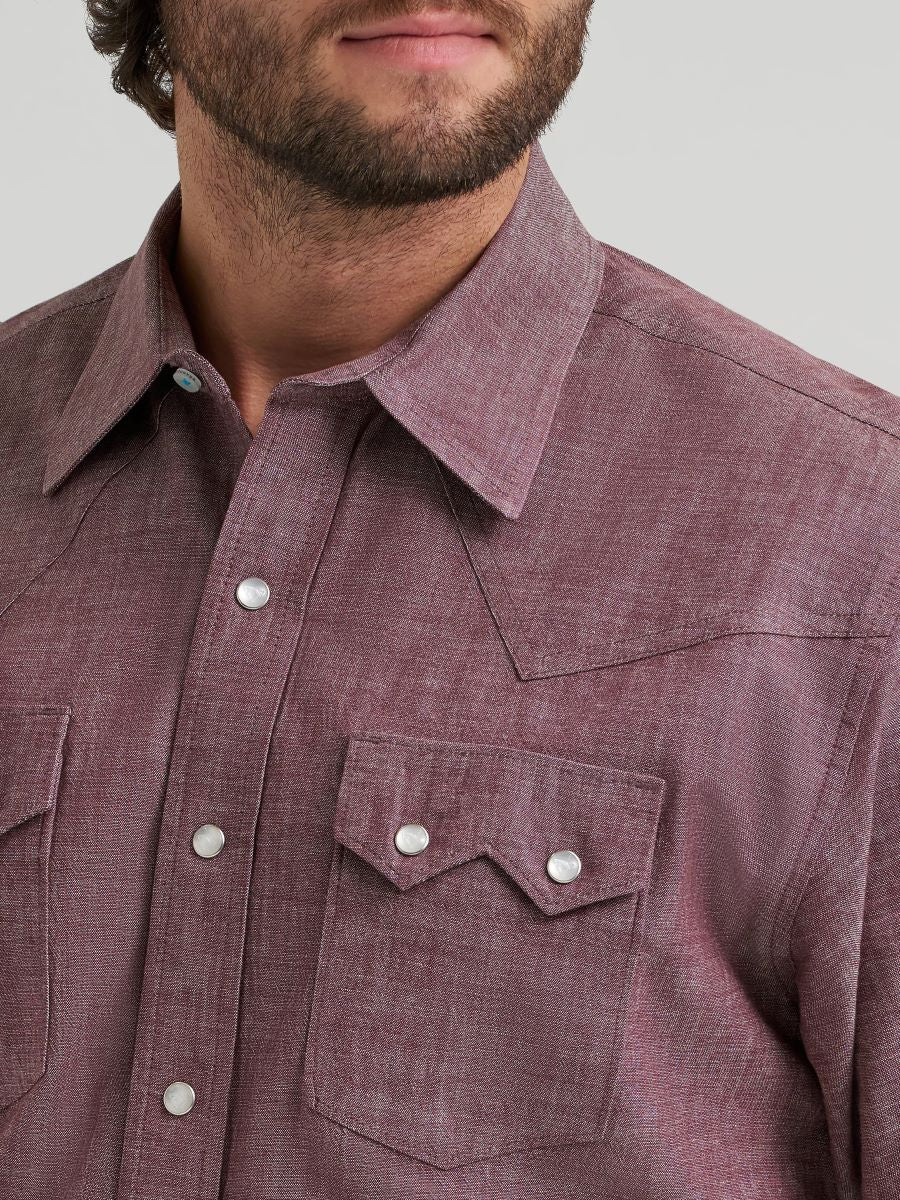 Close-up of a Wrangler maroon button-up shirt with a pocket and buttons on a neutral background