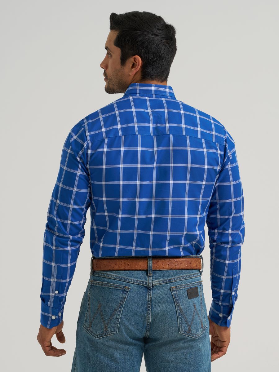 Man wearing a blue checkered Wrangler shirt and jeans on a plain background