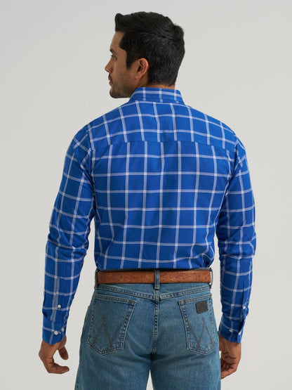 Man wearing a blue checkered Wrangler shirt and jeans on a plain background