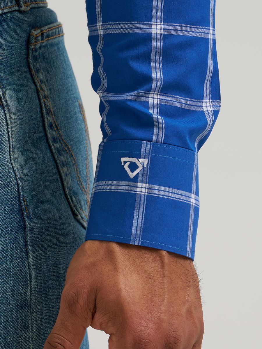 Close-up of a blue plaid Wrangler shirt sleeve with a brand logo on a gray background