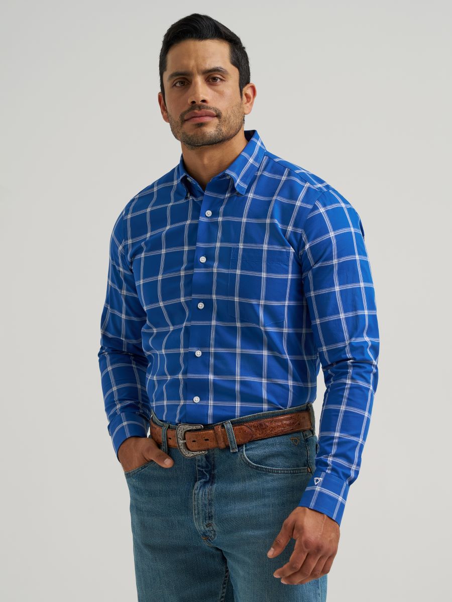Man wearing a blue checkered Wrangler shirt and jeans on a gray background