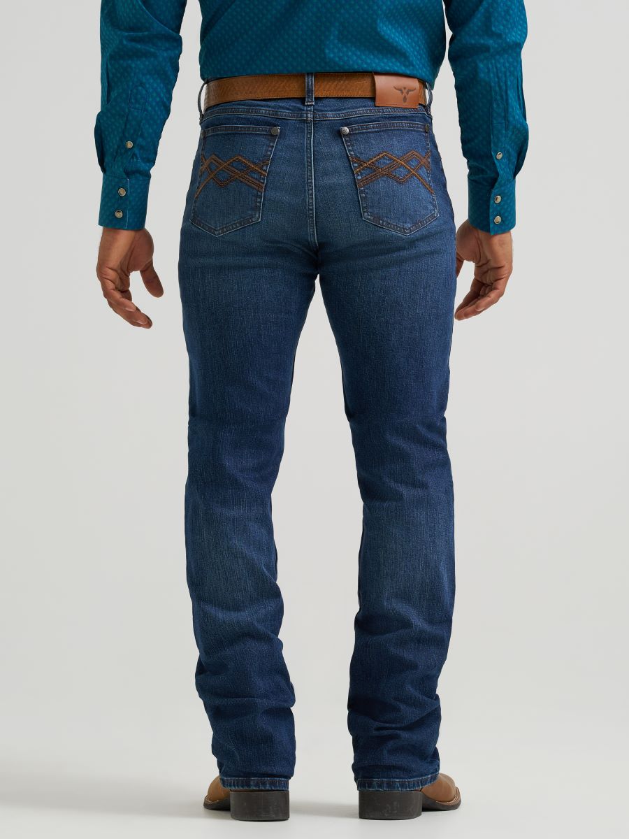 man wearing blue wrangler jeans and teal shirt on a white background