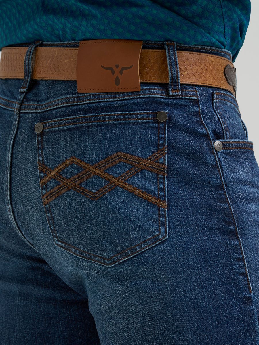 man wearing blue wrangler jeans and teal shirt on a white background