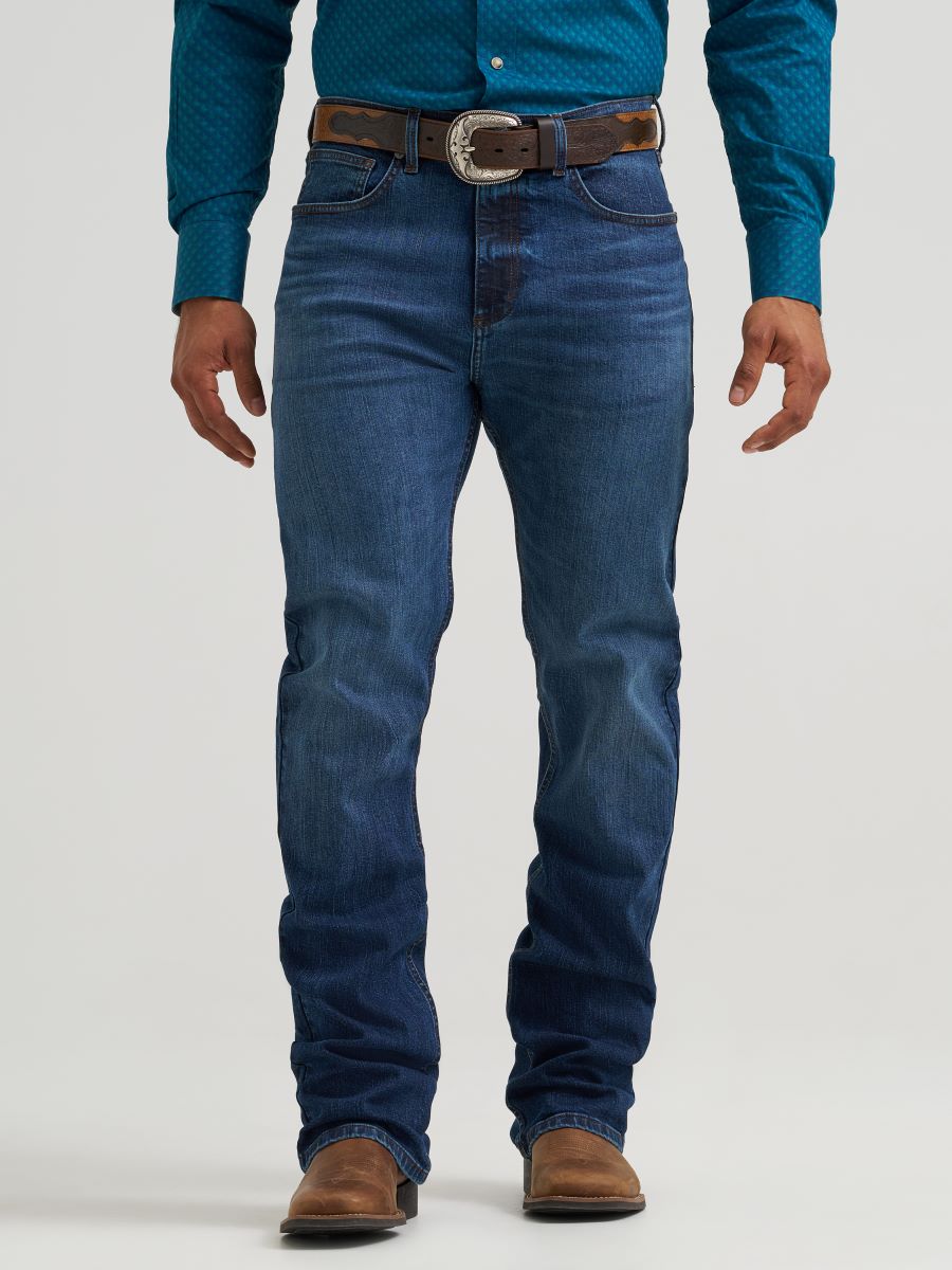 man wearing blue Wrangler jeans and teal shirt on a white background