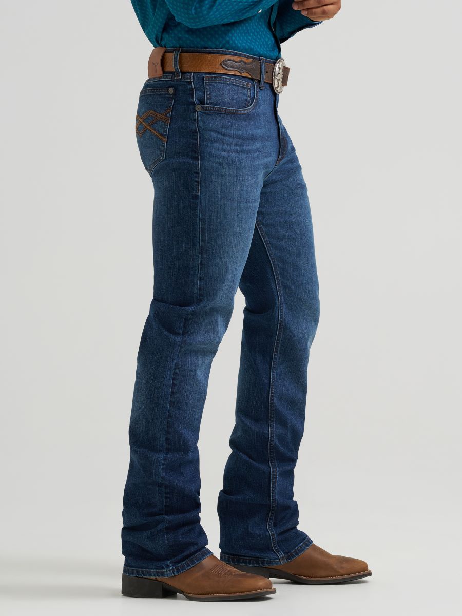 man wearing blue Wrangler jeans and teal shirt on a white background