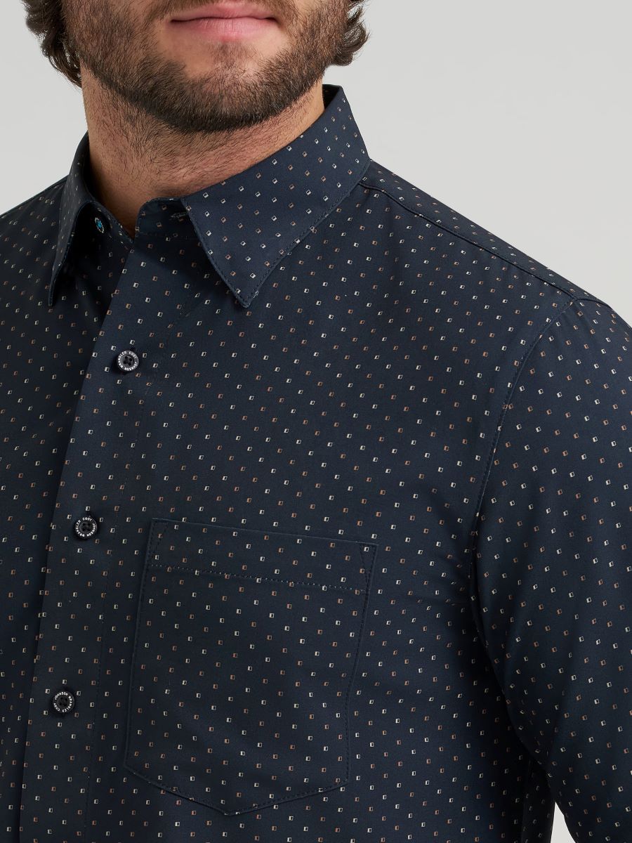 Man wearing a dark blue Wrangler shirt with a subtle pattern on a plain background