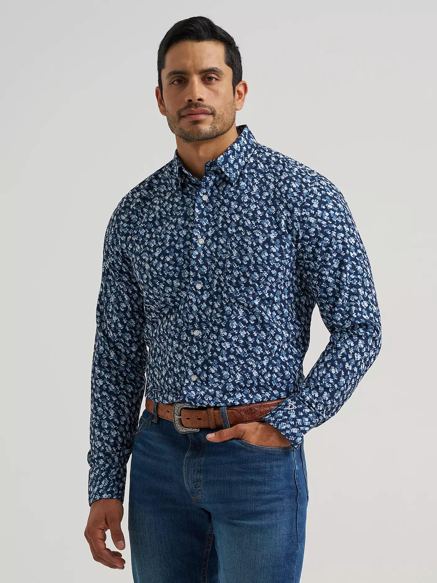 Man wearing a blue Wrangler shirt and blue jeans on a white background