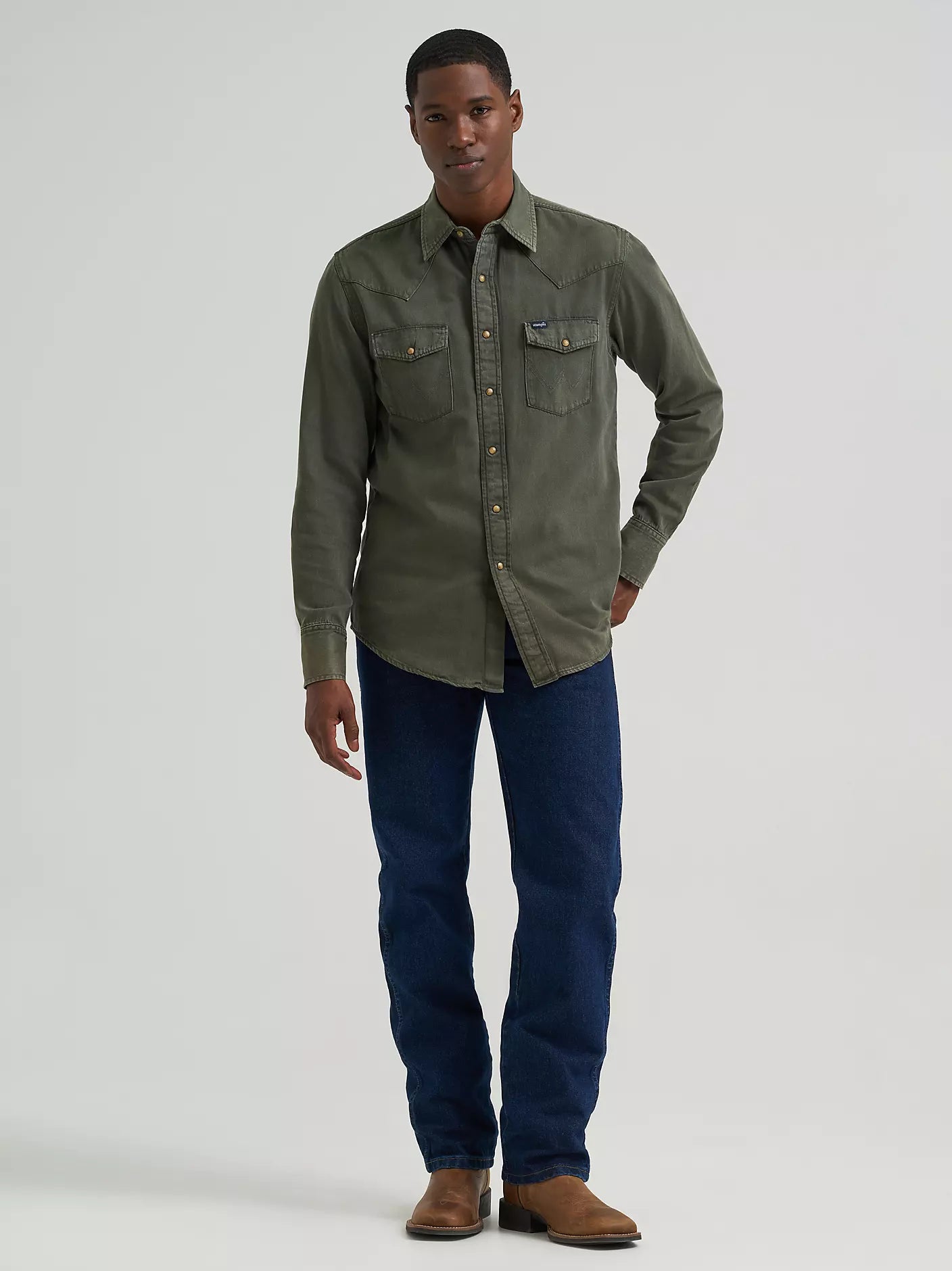 man wearing a green denim Wrangler shirt and blue jeans on a white background