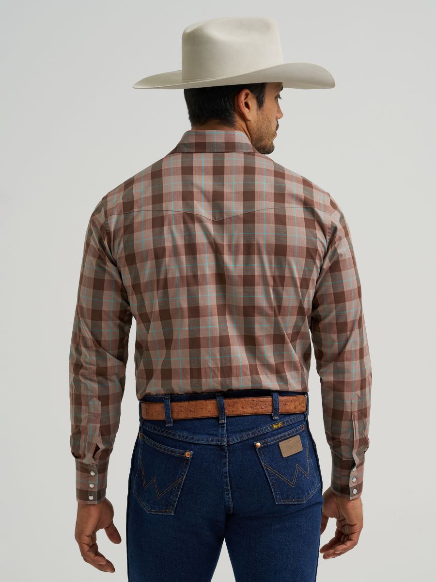 Man wearing a plaid Wrangler shirt, jeans, and a cowboy hat on a plain background