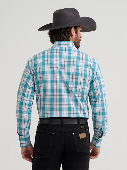 Man wearing a Wrangler turquoise and white checkered shirt with a black cowboy hat on a gray background
