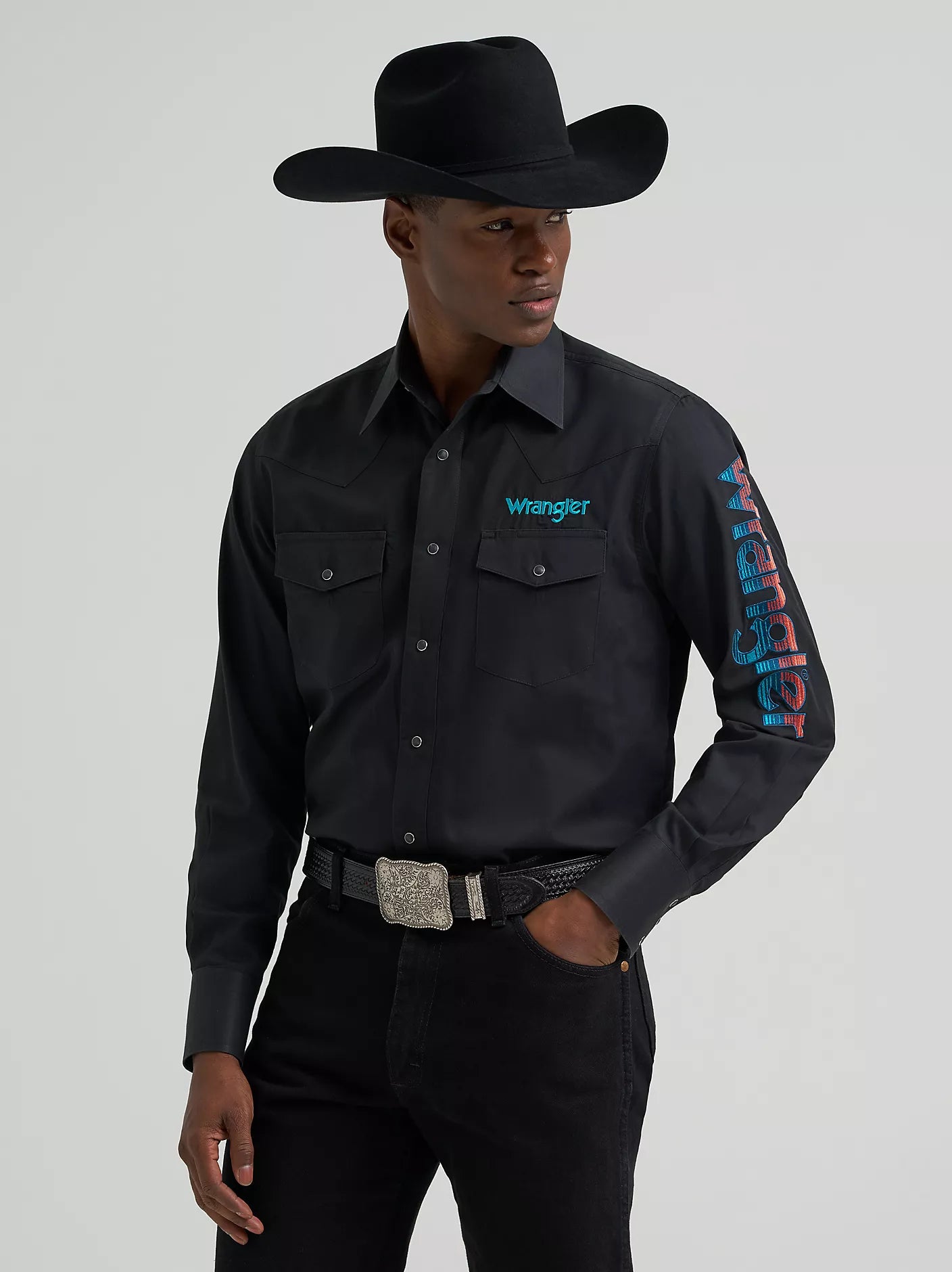 Person wearing a black Wrangler shirt with branding on a gray background