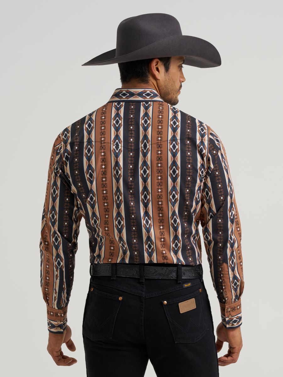 Man wearing a patterned Wrangler western shirt and cowboy hat on a gray background
