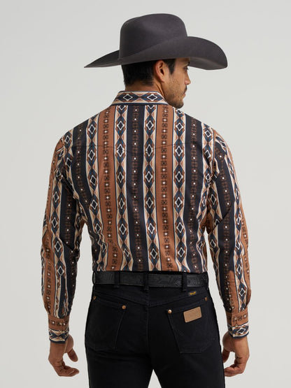 Man wearing a patterned Wrangler western shirt and cowboy hat on a gray background