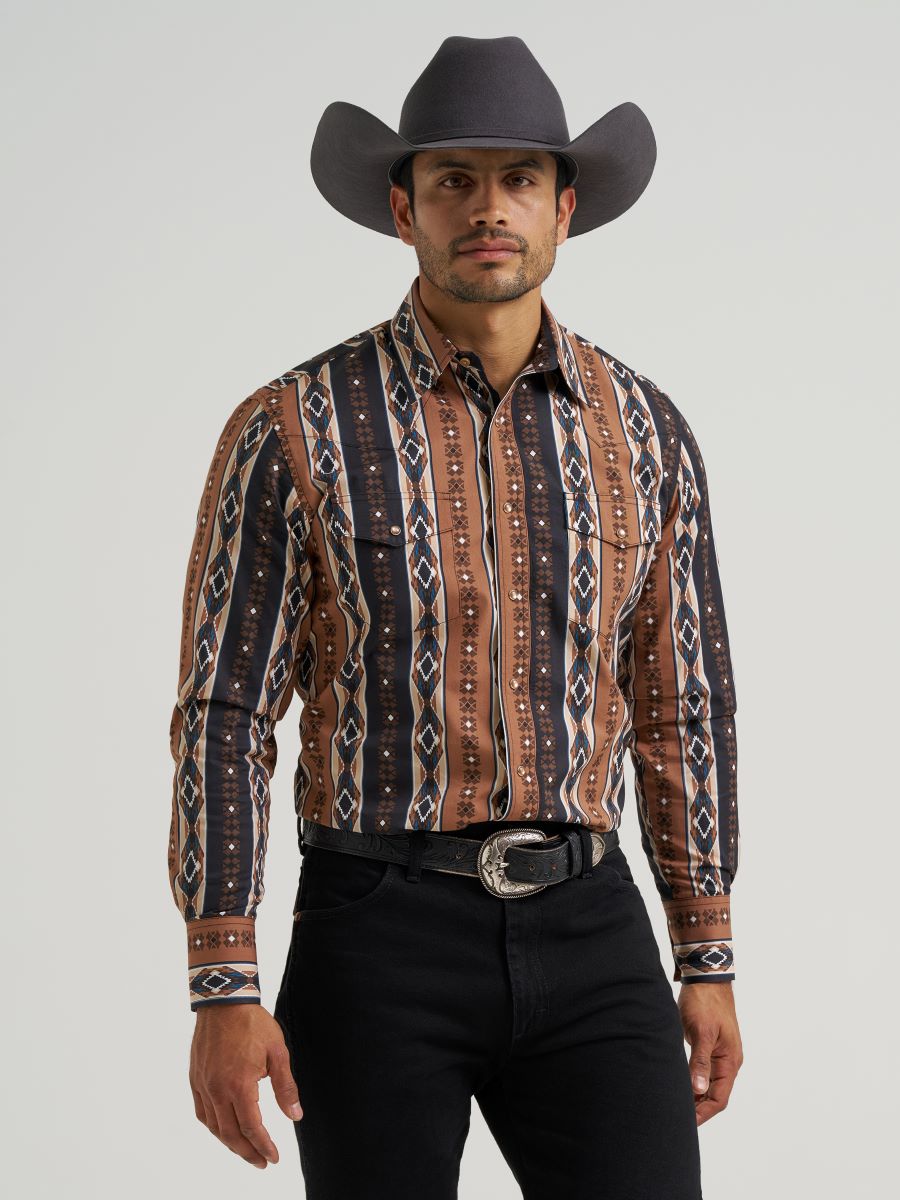 Man wearing a patterned Wrangler western shirt and cowboy hat on a gray background