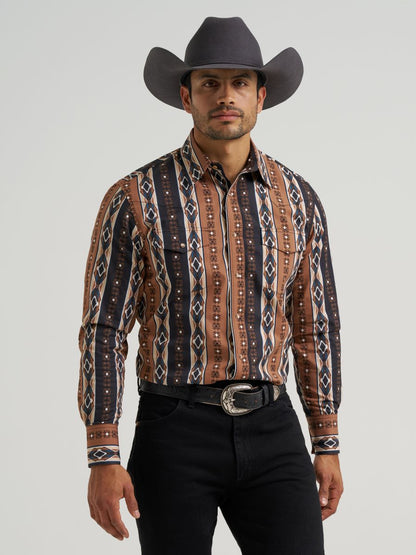 Man wearing a patterned Wrangler western shirt and cowboy hat on a gray background