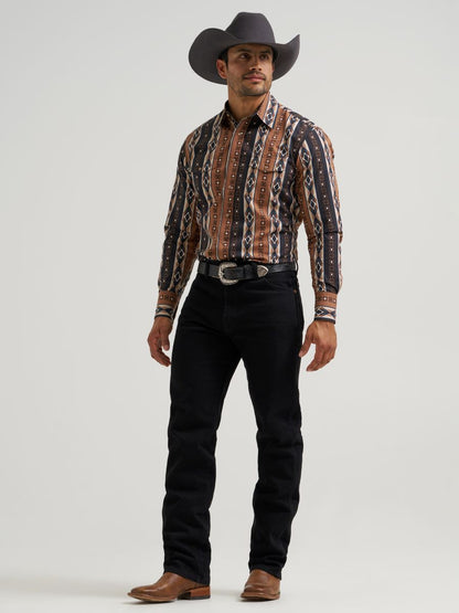Man wearing a patterned Wrangler shirt, black pants, and a cowboy hat on a white background