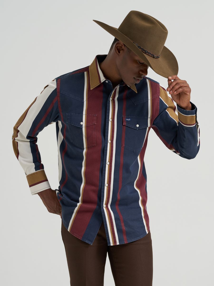 Person wearing a striped Wrangler shirt and cowboy hat on a plain background