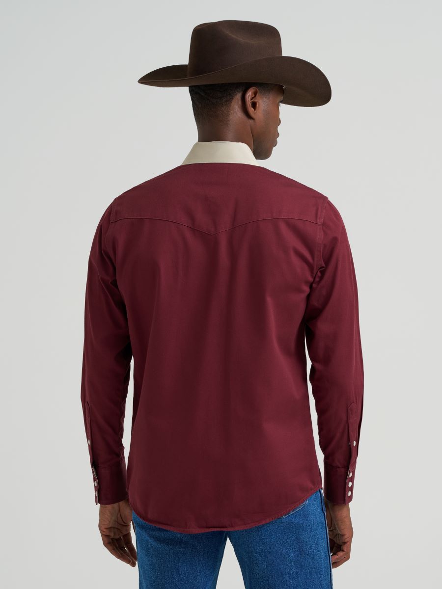 Man wearing a maroon and beige long-sleeve Wrangler shirt with a cowboy hat on a white background