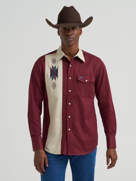 Man wearing a maroon and beige long-sleeve Wrangler shirt with a cowboy hat on a white background 