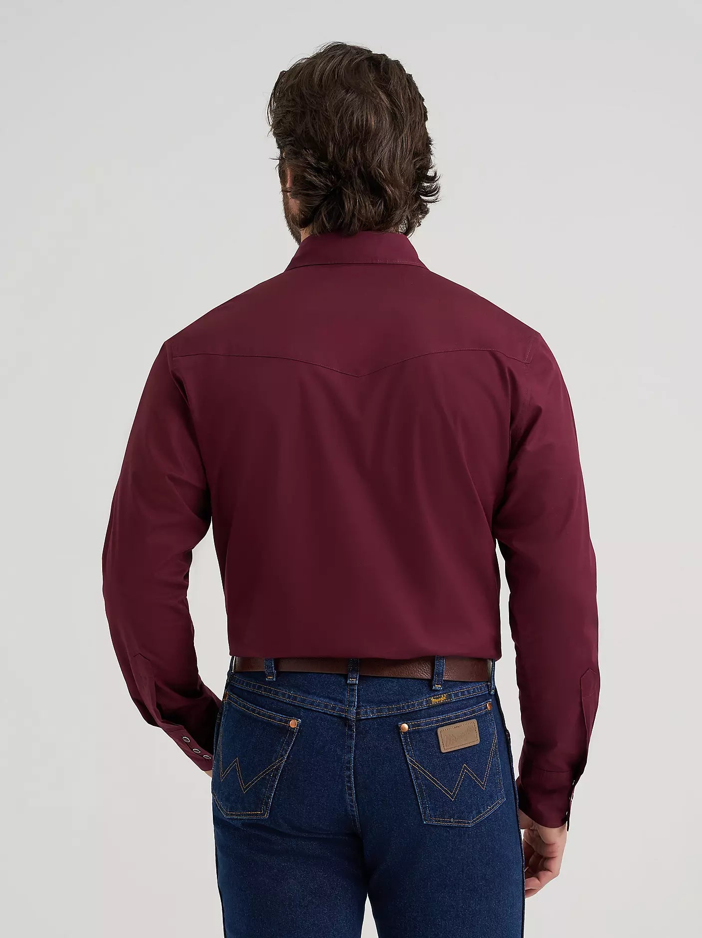 man wearing a burgundy Wrangler shirt, blue jeans on a white background