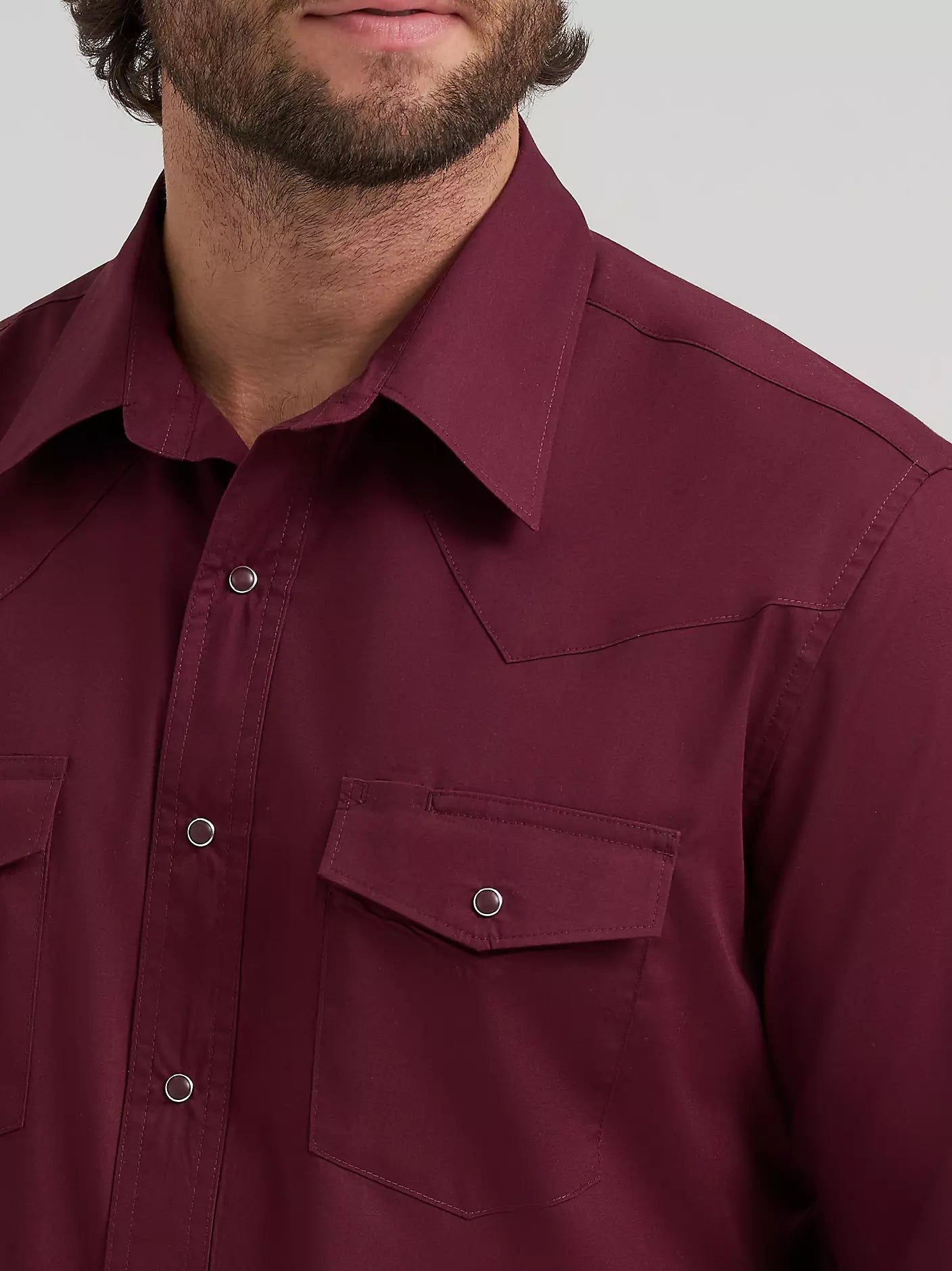 man wearing a burgundy Wrangler shirt on a white background