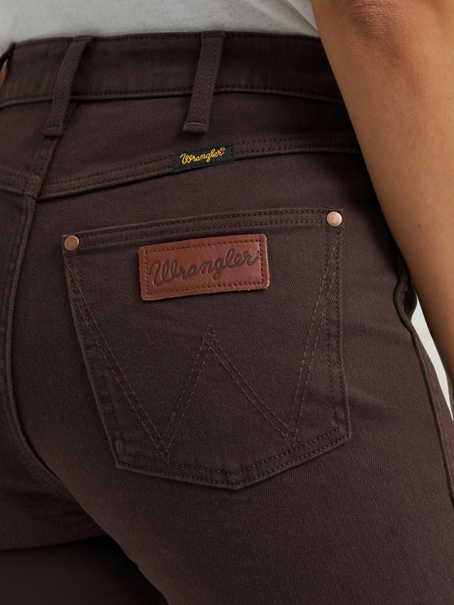 woman wearing brown Wrangler jeans and a white shirt on a white background
