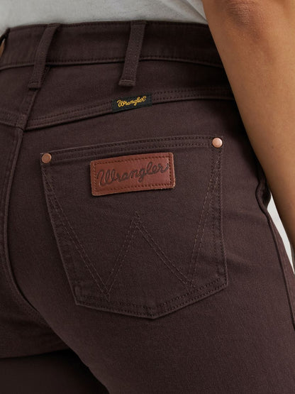 woman wearing brown Wrangler jeans and a white shirt on a white background