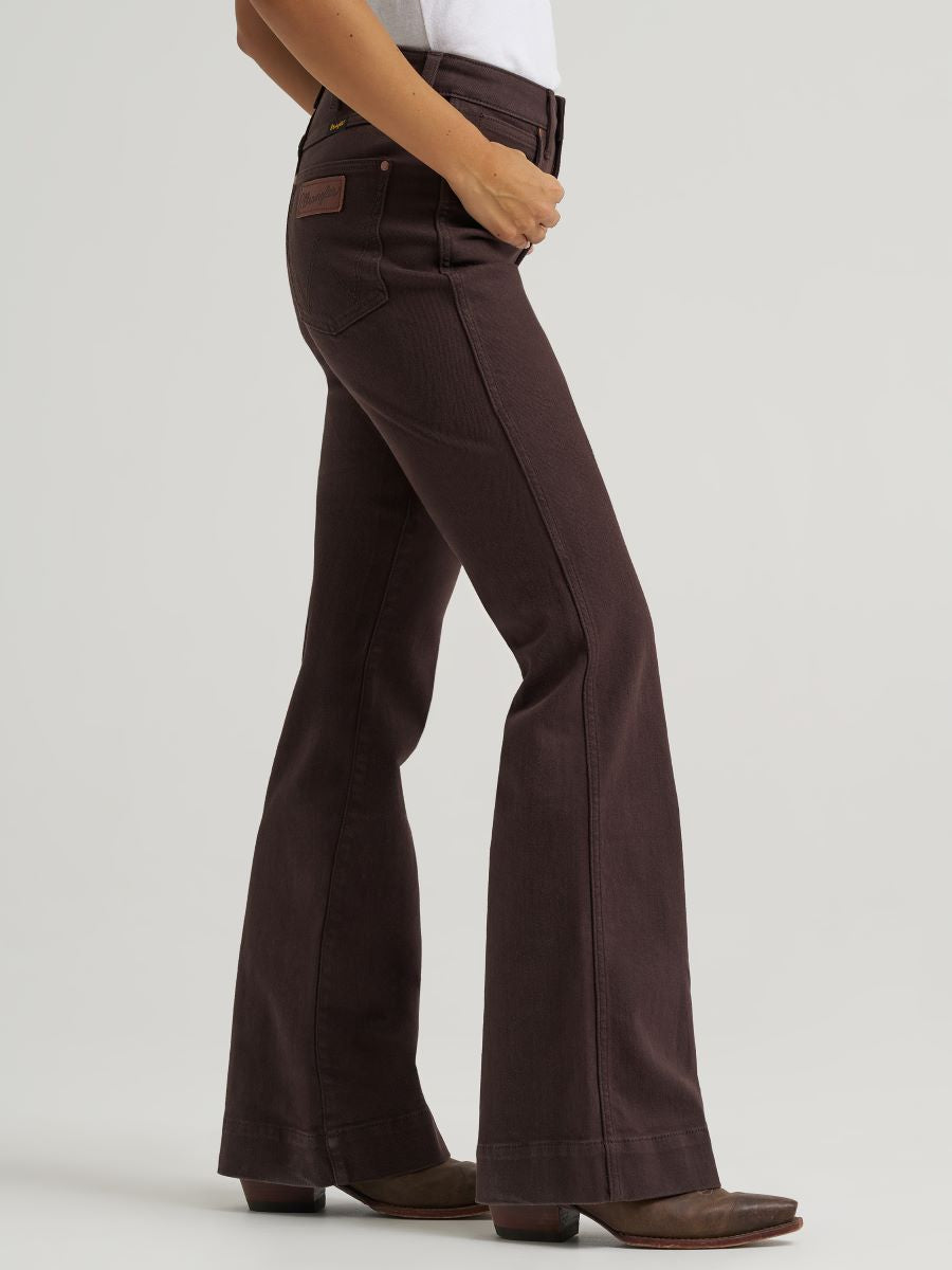 woman wearing brown Wrangler jeans and a white shirt on a white background