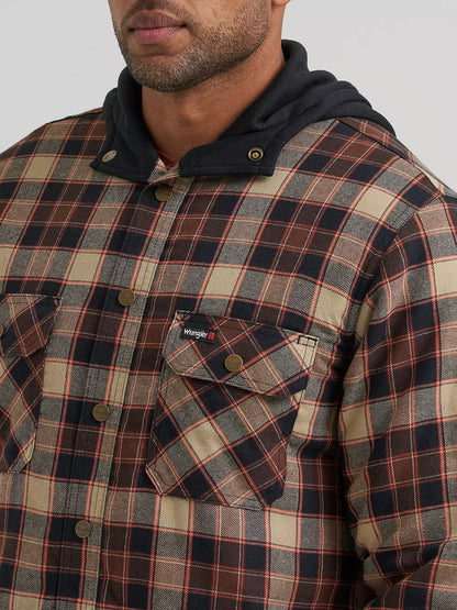 A close-up of a man wearing a plaid hooded Wrangler jacket. The garment features a beige, brown, and red plaid pattern with a dark navy hood and matching brown button details.