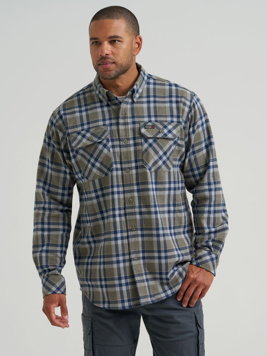 A man wearing a Wrangler long-sleeve plaid button-down shirt in blue, gray, and beige tones, paired with dark gray cargo pants, against a light gray studio background.