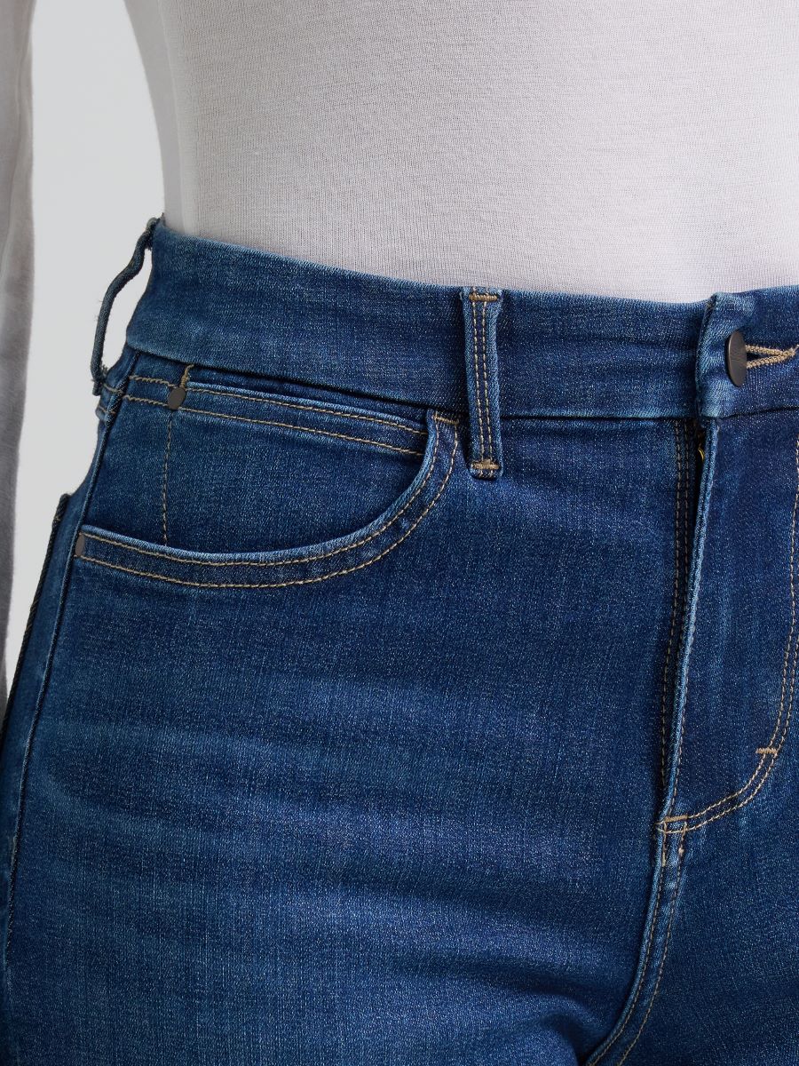 Person wearing blue Wrangler jeans on a white background