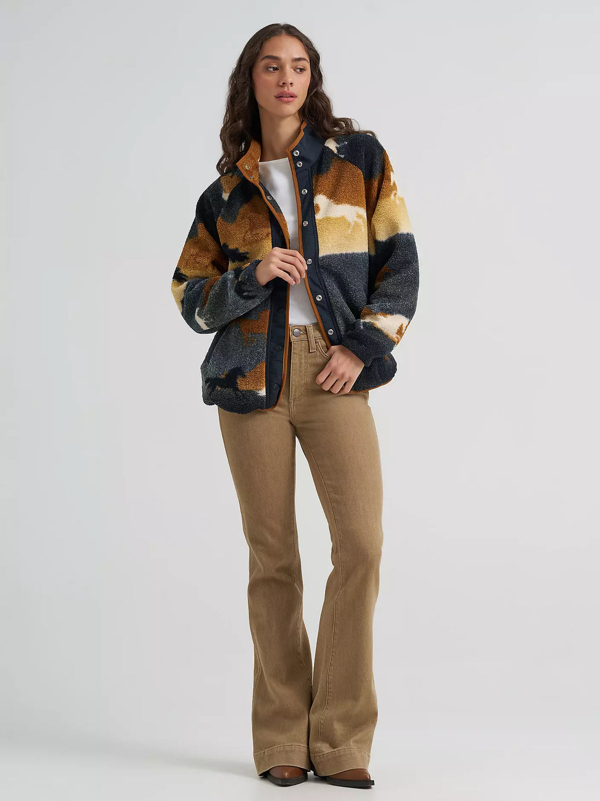 woman wearing a sherpa fleece Wrangler sweater,a white shirt and brown jeans on a white background