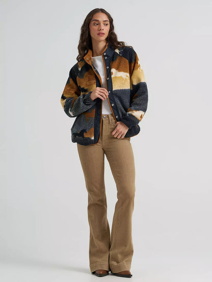 woman wearing a sherpa fleece Wrangler sweater,a white shirt and brown jeans on a white background