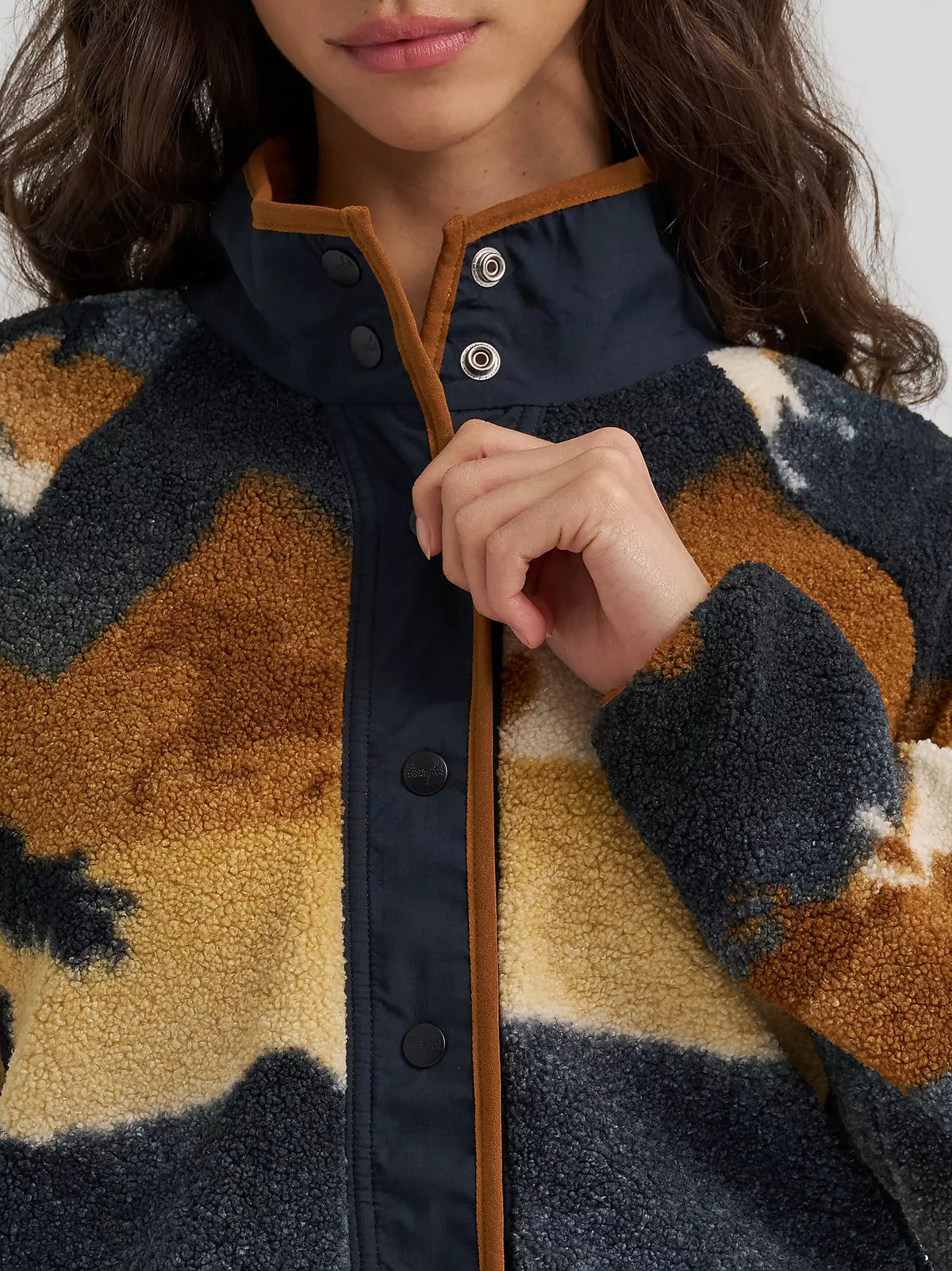 Close up of a woman wearing a Wrangler shera fleece sweater with snap closure on a white bakground