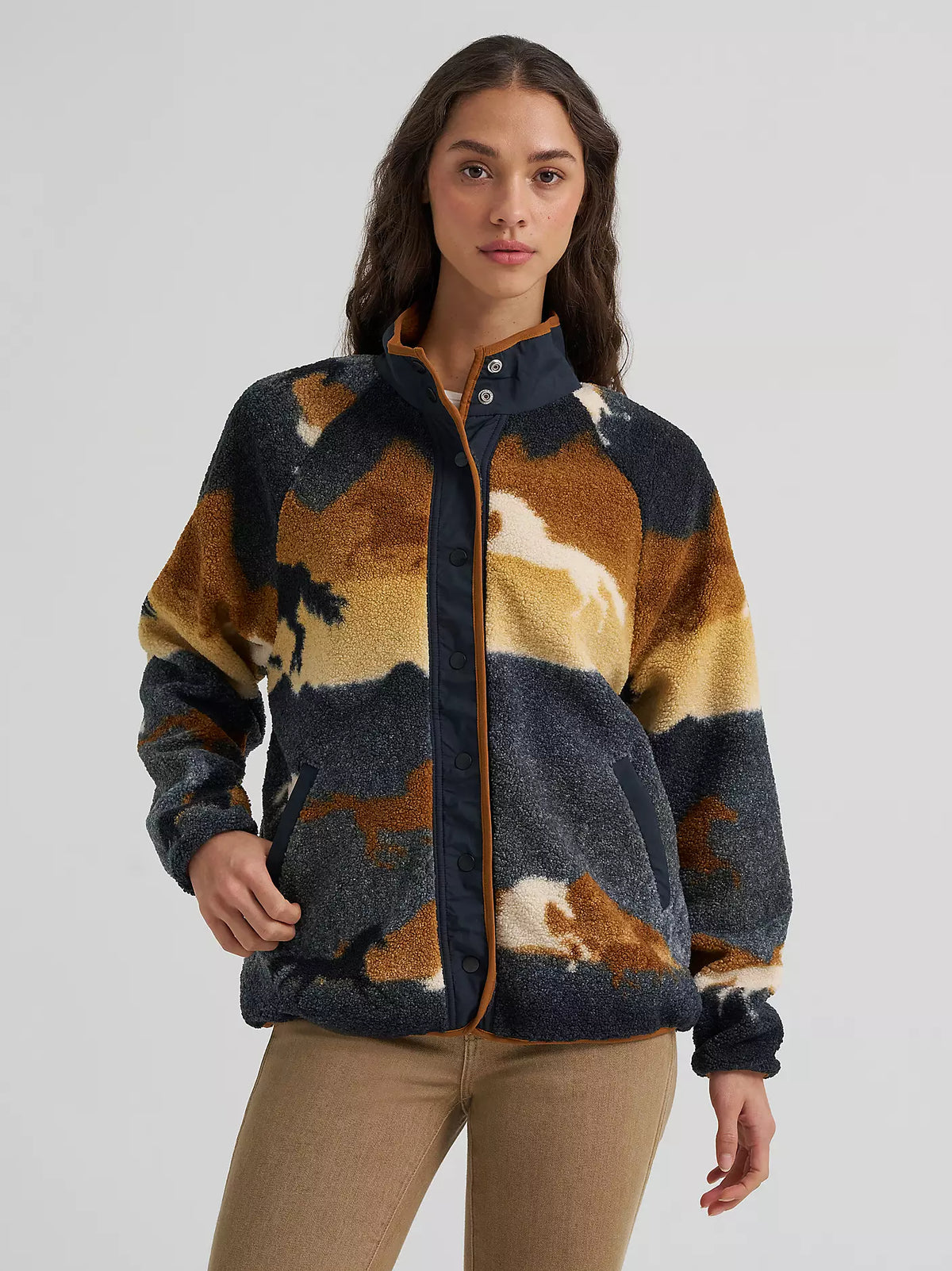 woman wearing a sherpa fleece Wrangler sweater and brown jeans on a white background
